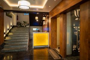 a lobby with a staircase with a yellow wall at HOTEL BLUE REGENT in Port Blair