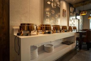 una fila di pentole e padelle su un bancone con piatti di HOTEL BLUE REGENT a Port Blair