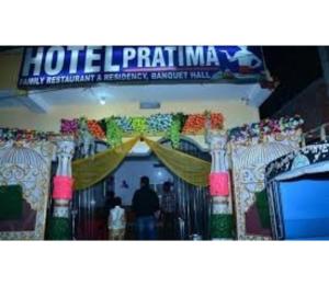 a room with a curtain and people standing in a room at Hotel Pratima And Banquet Hall, Muzaffarpur in Muzaffarpur