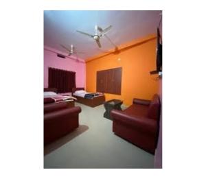 a living room with two couches and a ceiling fan at Hotel Pratima And Banquet Hall, Muzaffarpur in Muzaffarpur