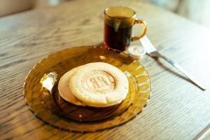 een bord met een kopje koffie op een tafel bij 江ノ電の線路沿いにある宿【film koshigoe】 in Kamakura