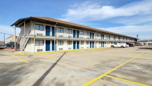 a building with a car parked in a parking lot at Motel 6-Dyersburg, TN in Dyersburg