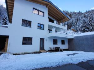 un edificio blanco con nieve en el suelo en New apartment in the beautiful Pitztal, en Oberlehn