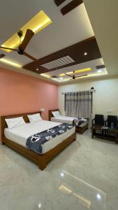 亨比的住宿－Mamatha Guest inn，一间带两张床和一张沙发的卧室