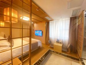 a hotel room with a bed and a window at Fresh Hours Hotel - West Lake Qingchun in Hangzhou