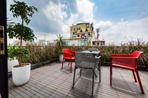 a patio with four chairs and a table and a building at Night Hotel in Hanoi