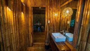 a wooden bathroom with a sink and a mirror at Barya Lang Villa- Native villa with jeepney room in El Nido