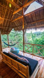 a bed in a room with a view of a forest at Barya Lang Villa- Native villa with jeepney room in El Nido