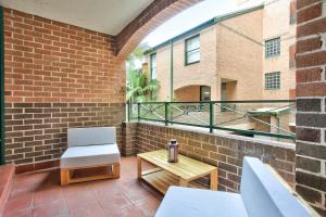 Un balcón con una silla y una mesa y un edificio en Stylish 2 Bedroom Apartment Chippendale en Sídney