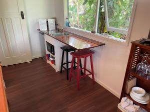 a kitchen with a counter with a sink and a stool at Bellingen Treehouse in Bellingen