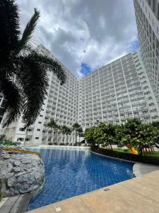 - un grand bâtiment avec une grande piscine en face dans l'établissement Shore residences Ph, à Manille