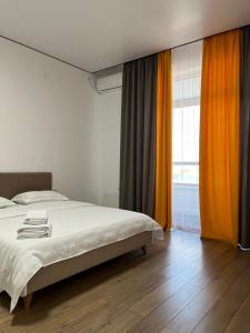 a bedroom with a bed and a large window at Raisson Ahotel GT32 in Astana