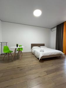 Dormitorio blanco con cama y mesa en Raisson Ahotel Grand Turan 32, en Astana