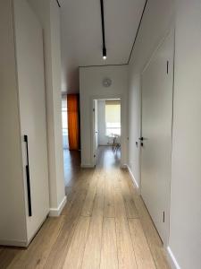 an empty hallway with white walls and wood floors at Raisson Ahotel GT32 in Astana