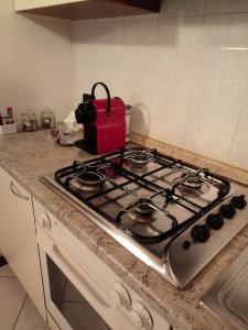 a stove top in a kitchen with a red appliance at La casa di Davide con giardino e garage in Verona