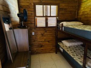 a room with two bunk beds and a window at Chalés confortáveis in Rio Grande