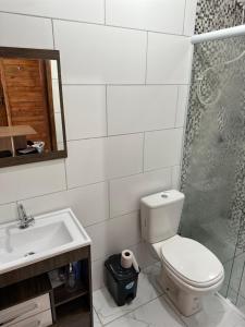 a bathroom with a toilet and a sink and a shower at Chalés confortáveis in Rio Grande +12 photos