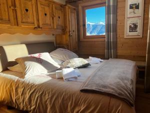 ein großes Bett in einem Zimmer mit Fenster in der Unterkunft Le Rocher Blanc A in Courchevel