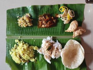 a green plate with different types of food on a banana leaf at Mamatha Guest inn in Hampi