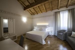 una camera da letto con un letto, un divano e un tavolo di Hotel Sesmones a Lodi