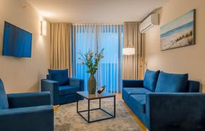a living room with two blue couches and a table at ORBI CITY - Central Apartment in Batumi