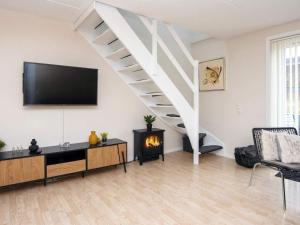 a living room with a tv and a staircase at 4 star holiday home in Rømø-By Traum in Sønderby