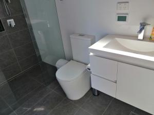 uma casa de banho com um WC, um lavatório e um chuveiro em Brand NEW VIP Luxury 5/5 Star Beachside Escape em Sydney