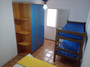 een kleine kamer met een stapelbed en een kast bij Apartamento Pé Na Areia in Mongaguá