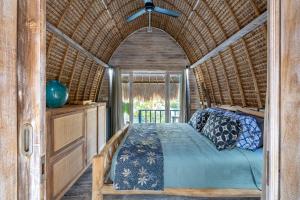 una camera con letto in una stanza con soffitto di Laguna Biru a Nusa Lembongan