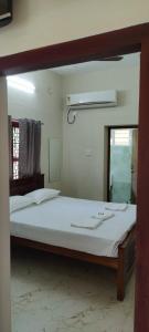 um quarto com uma cama grande e um espelho em Beun Residency em Nagercoil