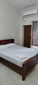a bedroom with a large bed with white sheets at Beun Residency in Nāgercoil