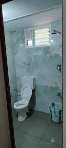 uma casa de banho com um WC branco e uma janela em Beun Residency em Nagercoil