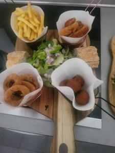 three baskets of food on a cutting board with french fries at Chalet en A de la Motte-Fanjas 