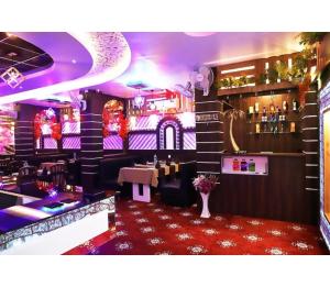 a restaurant with a bar with a red carpet at Hotel Janvi International Inn, Muzaffarpur in Muzaffarpur