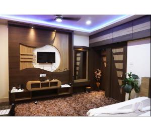 a bedroom with a tv on a wall at Hotel Janvi International Inn, Muzaffarpur in Muzaffarpur