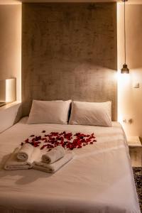 a white bed with red roses on it at Agia Sofia luxury suite & spa in Thessaloniki