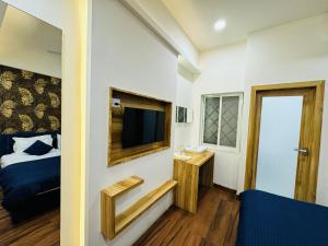 a small room with a bed and a television at Hotel shree mahakal krapa in Ujjain