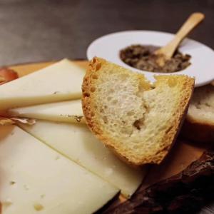 a plate of cheese and bread and a bowl of dips at Cortona Resort & Spa in Cortona