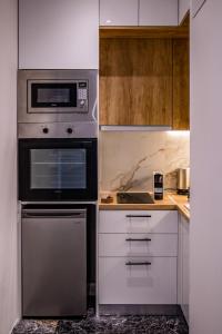 a kitchen with a stove and a microwave at Agia Sofia luxury suite & spa in Thessaloniki