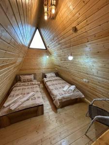a room with two beds in a wooden cabin at Dilijan Gold Resort in Dilijan