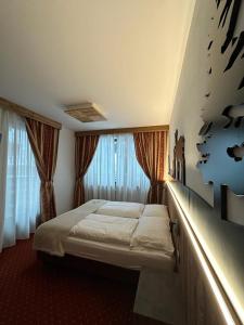 カリゾーロにあるAlbergo Garni Martinaのベッドルーム1室(ベッド1台付)、壁に鳥が飾られています。
