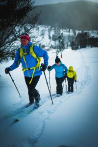 trójka ludzi biegnie na nartach w śniegu w obiekcie Apartmán U Setra w mieście Pec pod Sněžkou