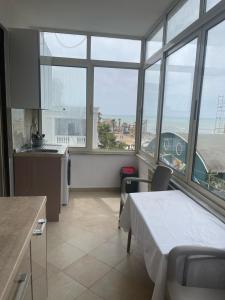 een keuken met een bed in een kamer met ramen bij MILA'S BEACH APARTMENT in Durrës