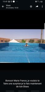 a man swimming in a swimming pool in a swimming pool at Camping-Auberge du Puigaudeau et Aziza in Atar