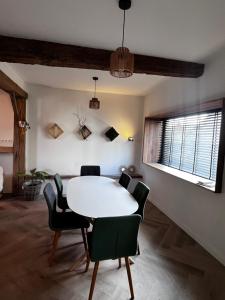 une salle à manger avec une table et des chaises blanches dans l'établissement De Koer Kanne, à Kanne