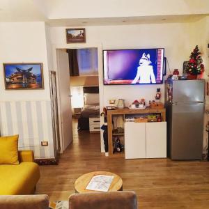 a living room with a refrigerator and a television on the wall at San Siro Dream Home -Apartment with garage-Milano in Milan