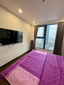 a bedroom with a purple bed and a large window at Hoang Huy Grand Tower - Apartment - Homestay in Hai Phong