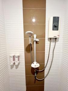 a shower in a bathroom with a hair dryer on a wall at Hangover Aonang in Ao Nang Beach