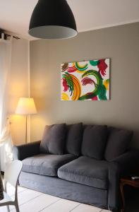 ein Wohnzimmer mit einem Sofa und einem Gemälde an der Wand in der Unterkunft Flo House, Università Bicocca in Mailand