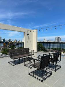 a patio with benches and tables and a view of the city at Khe Suites Serviced Apartment - Han River in Danang